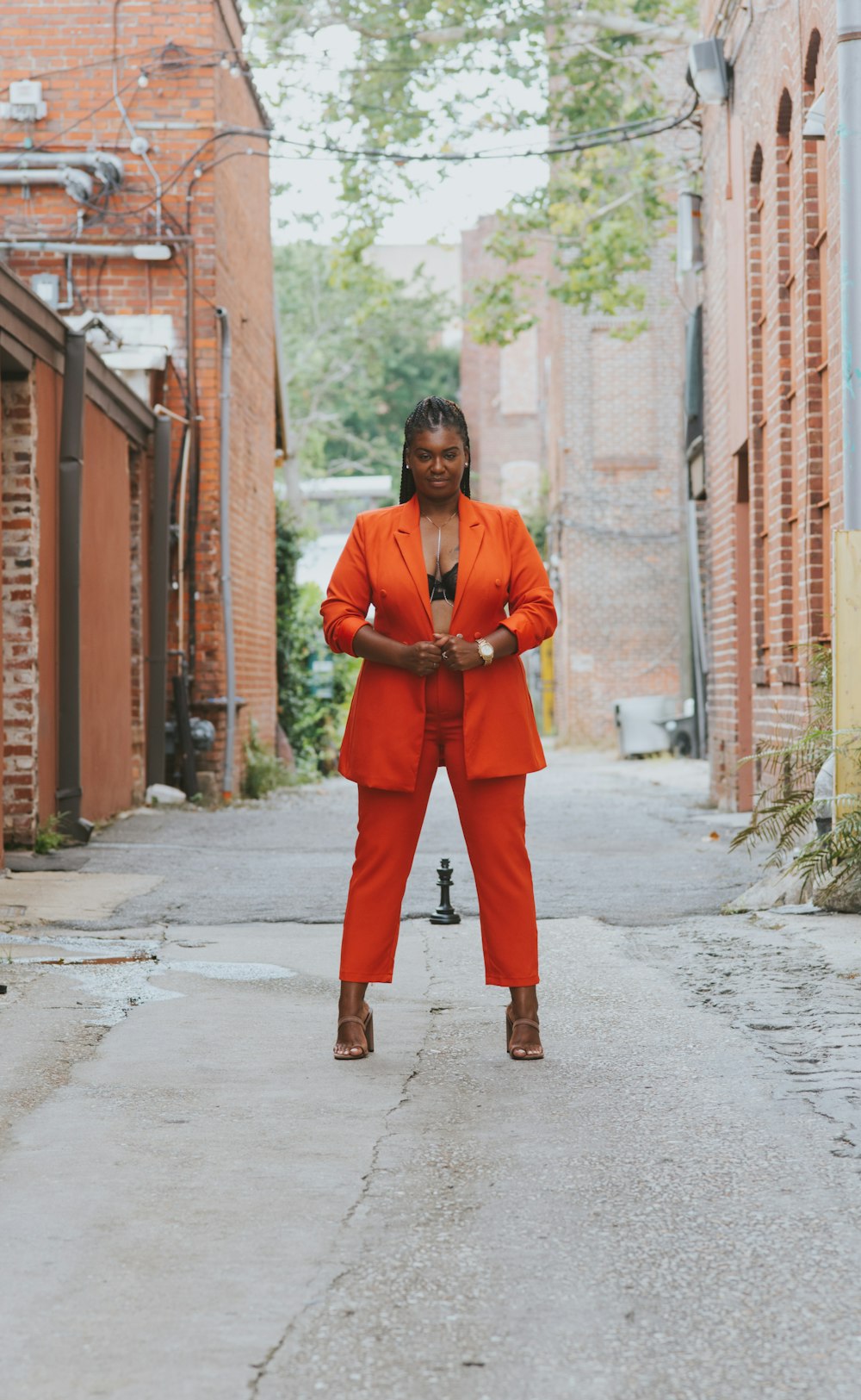 man in orange suit standing on sidewalk during daytime