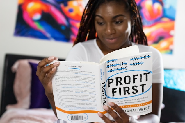 woman in white long sleeve shirt reading book about profits