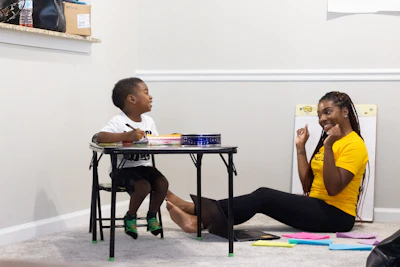 Child focused and engaged in a therapy exercise with supportive adult.