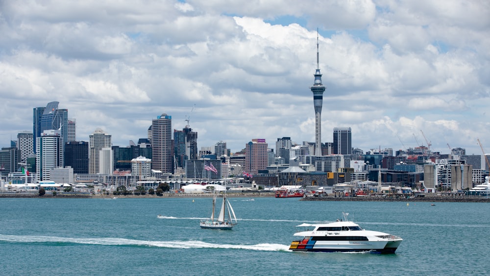 white and black boat on sea near city buildings during daytime