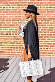 woman in black long sleeve dress holding magazine