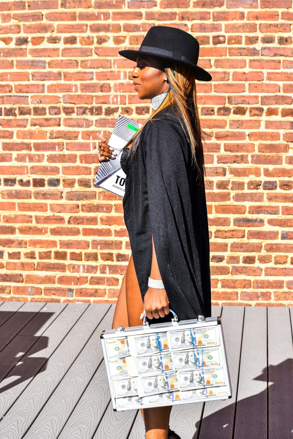 woman in black long sleeve dress holding magazine