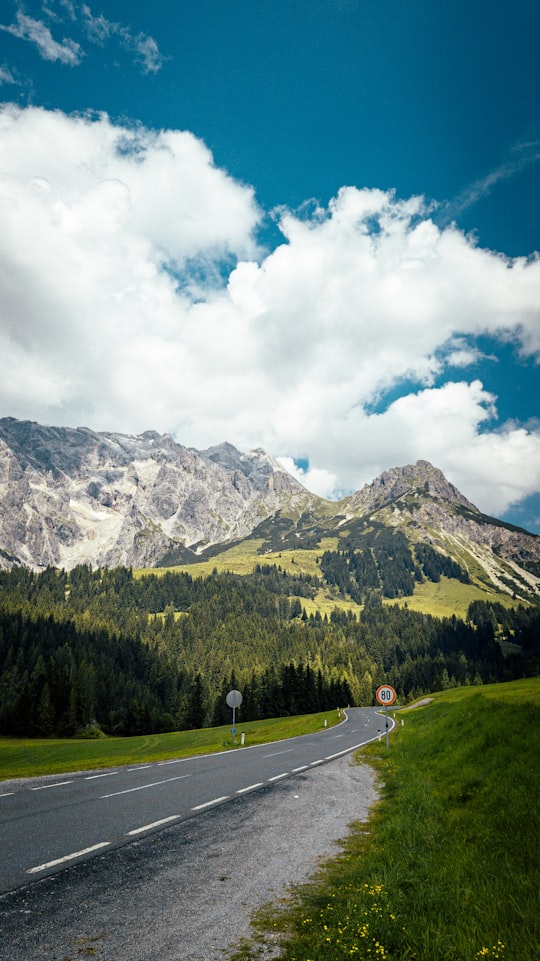 green trees near mountain under white clouds and blue sky during daytime in Hochkönig Austria