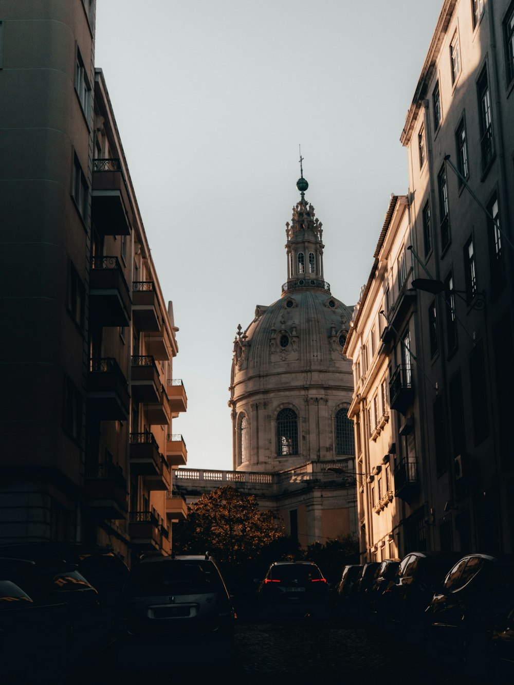 cars parked in front of brown concrete building during daytime