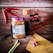 A happy middle-aged Indonesian woman holding a jar of black garlic in a cozy kitchen setting.