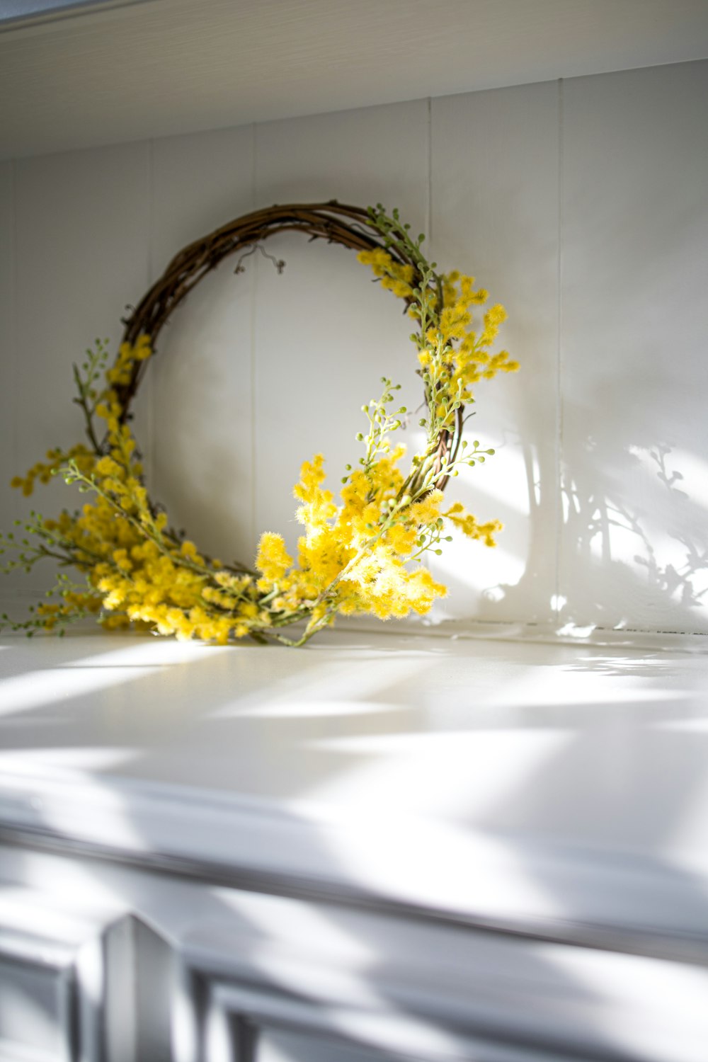 yellow flowers on white ceramic vase