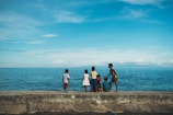 Children playing near traditional fishing nets under a bright blue sky