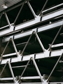 Close-up of shiny industrial steel beams stacked neatly in warehouse.