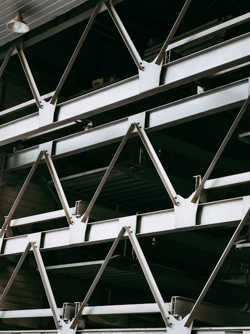 A close-up shot of lightweight steel beams stacked neatly in a bright warehouse.