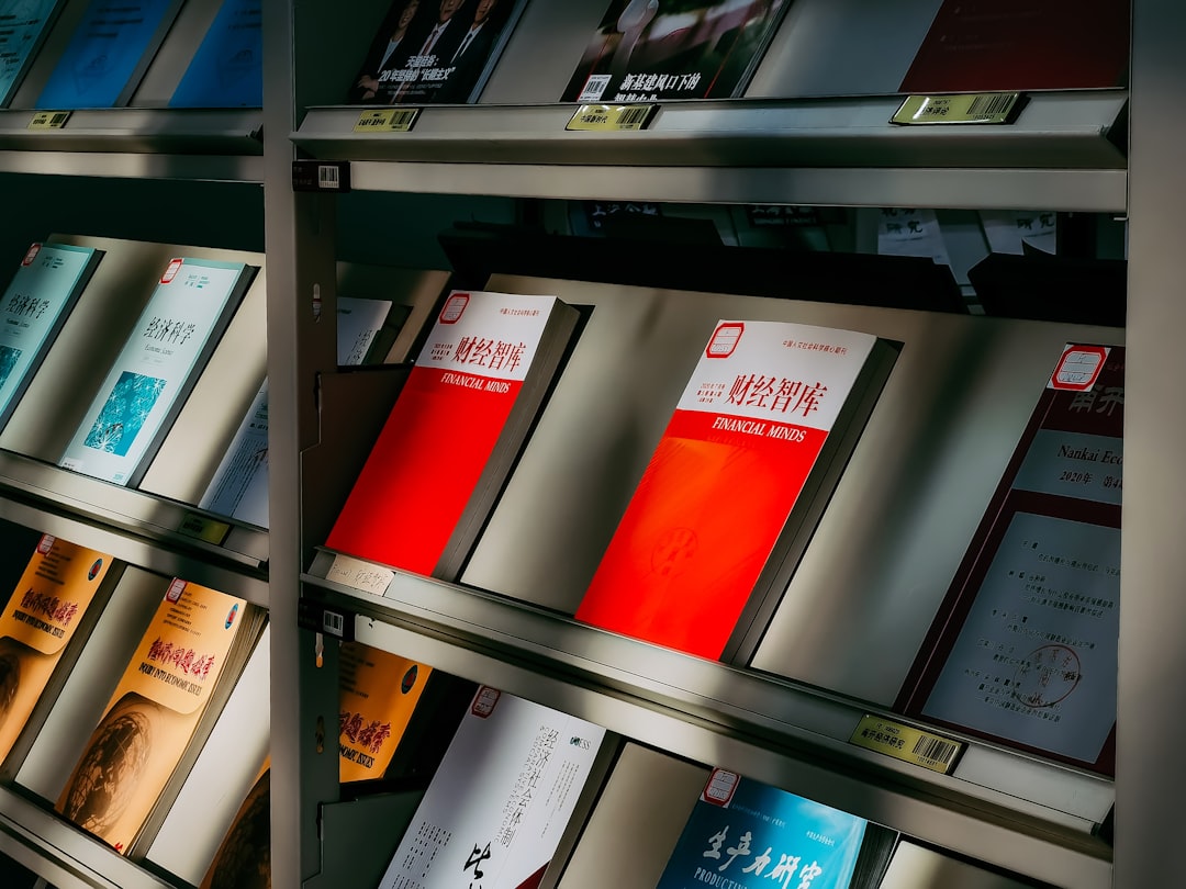 red and white book on black wooden shelf