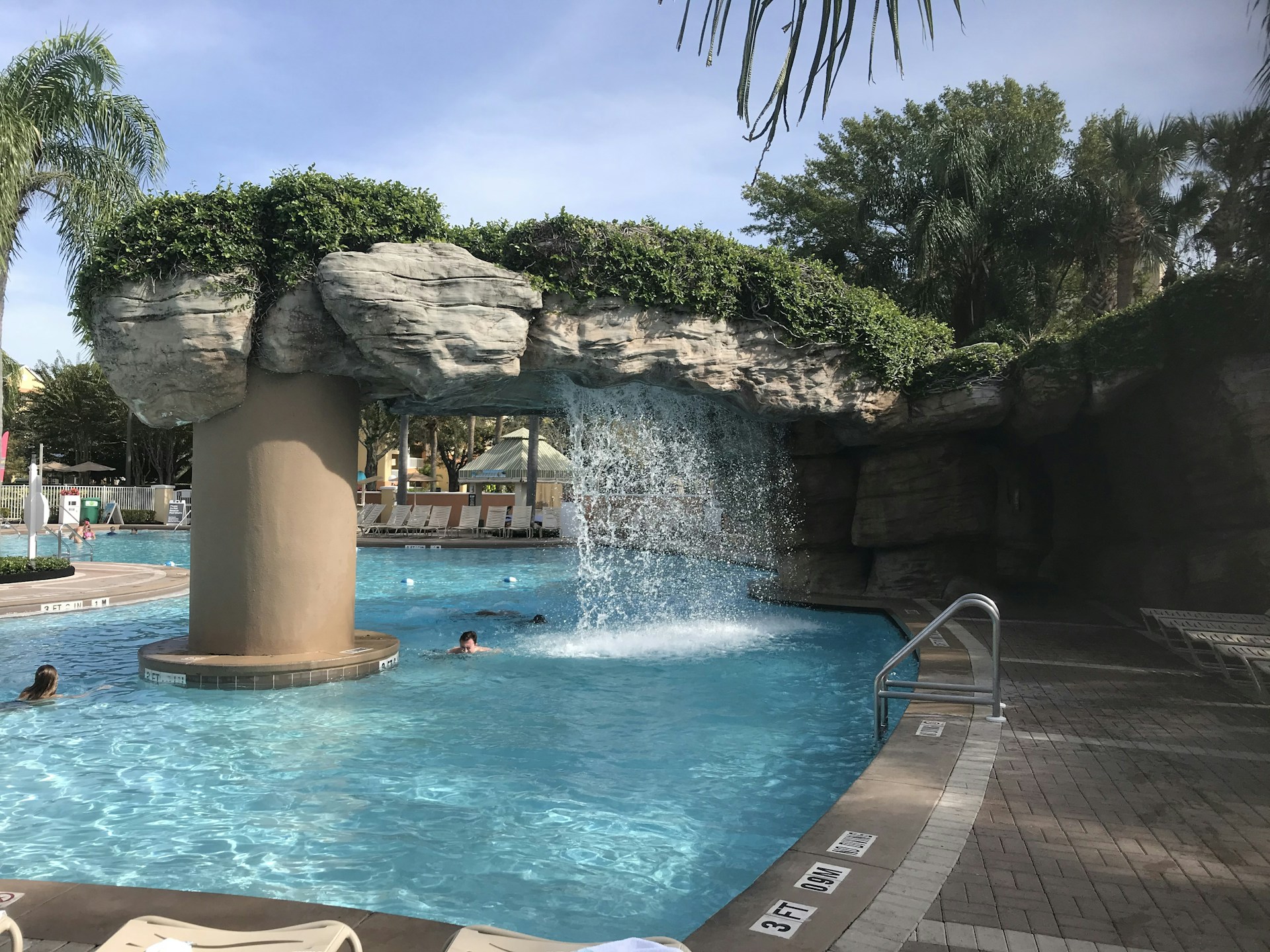 people swimming in pool during daytime