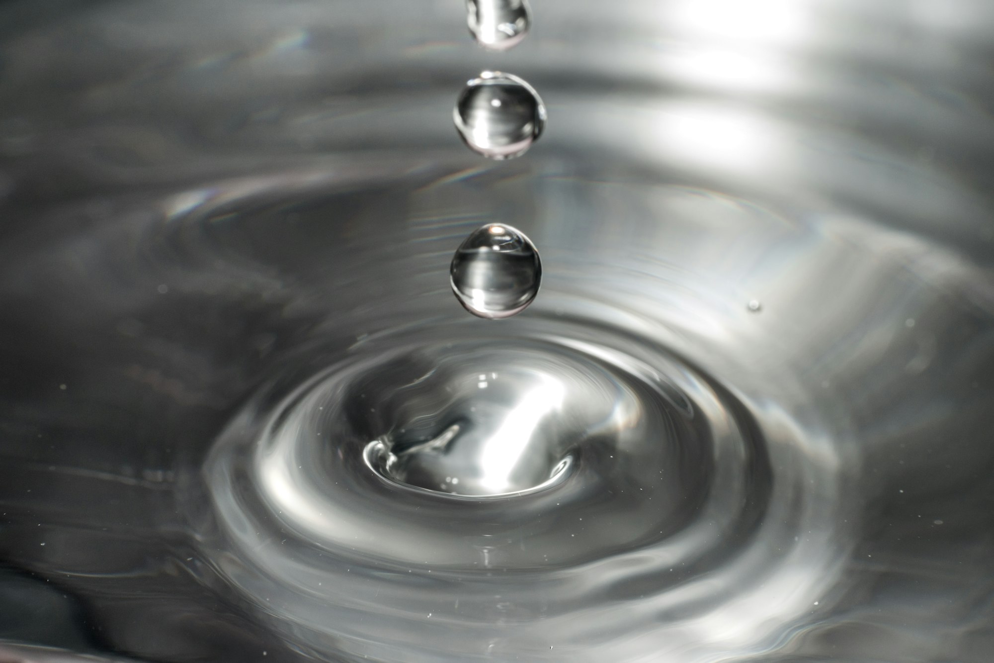 drops of water causing ripples in a shiny surface