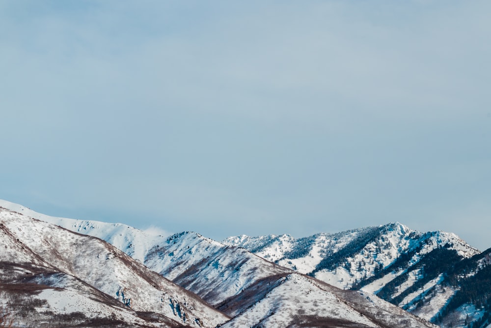snow covered mountains under white sky during daytime