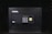 A black electronic safe with a keypad and a small digital display. The safe has a prominent brand logo on the front and a warning label at the top left corner. It is placed in a dark environment, enhancing its prominence and security features.