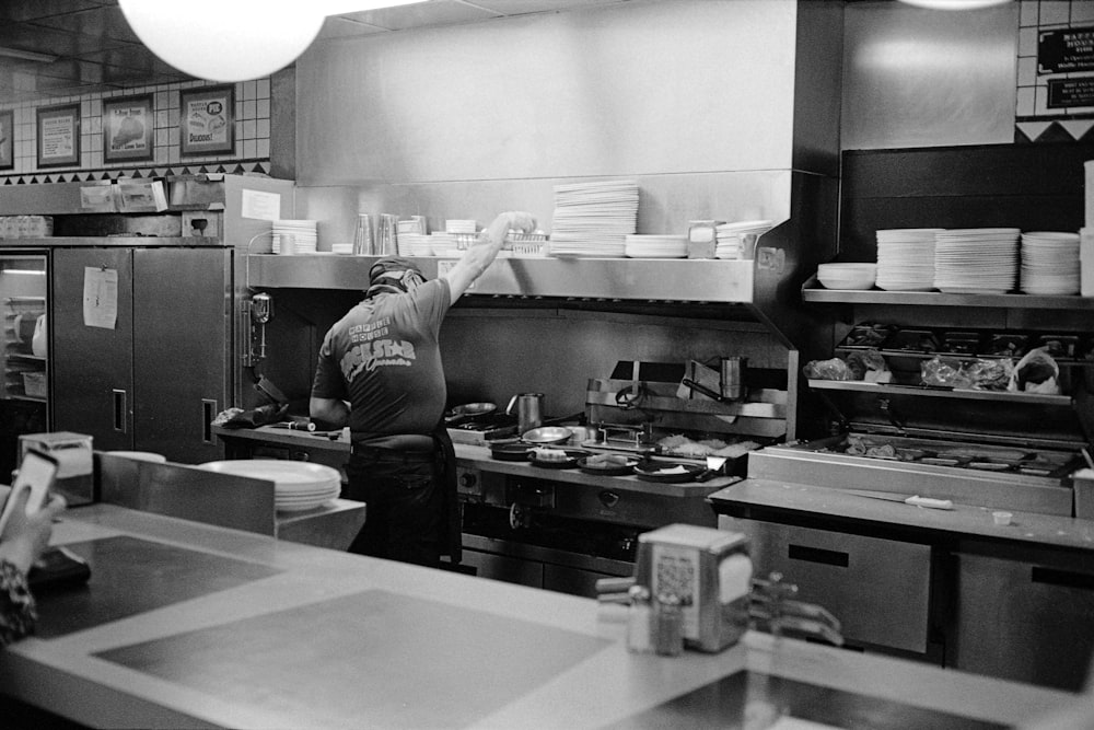 man in black long sleeve shirt standing in front of kitchen counter