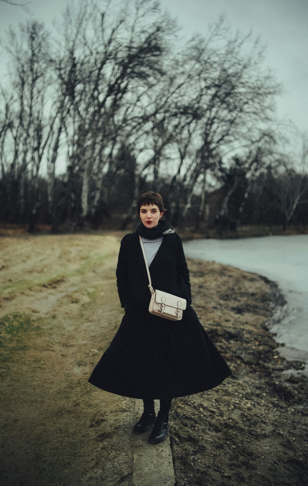 woman in black dress standing on green grass field