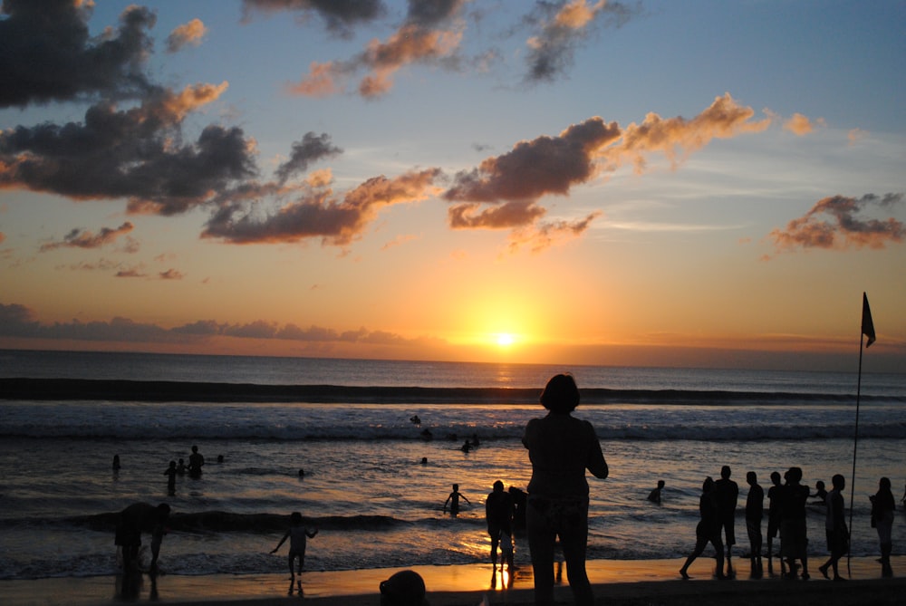 silhouette of people on beach during sunset