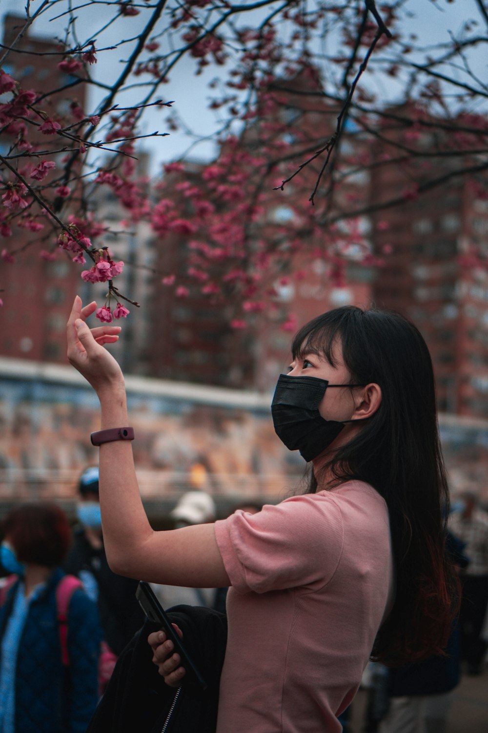 woman in pink long sleeve shirt holding black camera