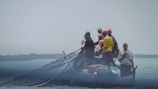 Fishermen working together on a small boat.