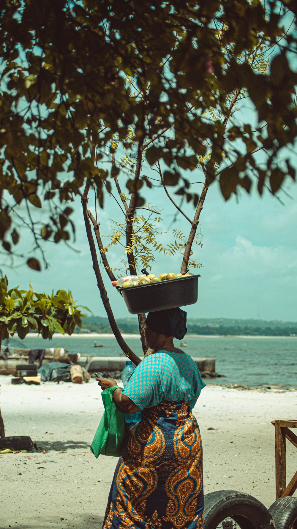 woman in green shirt sitting on beach shore during daytime