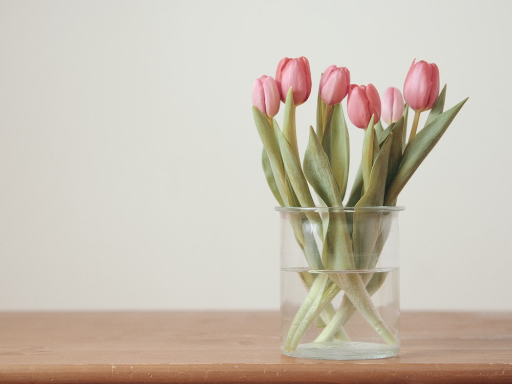 pink tulips on brown wooden table
