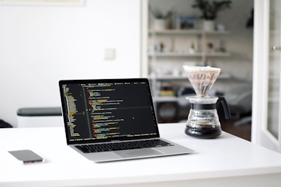 black laptop computer beside clear glass cup