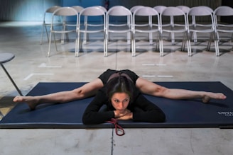 woman in black shirt lying on blue and white pool bed