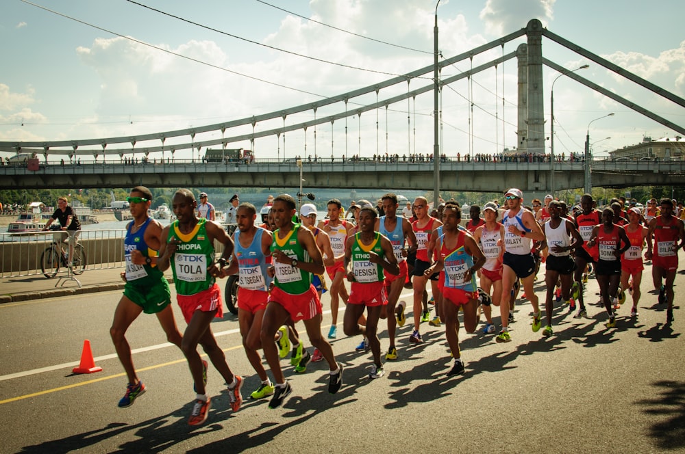 group of people running on gray concrete bridge during daytime