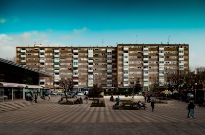 A modern city apartment building overlooking a bustling European square.
