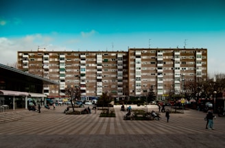 A modern city apartment building overlooking a bustling European square.