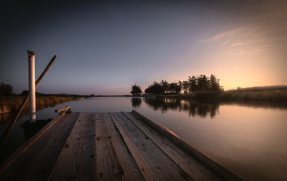 brown wooden dock over calm water during daytime