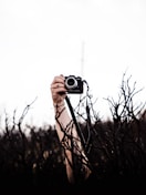 person holding black and silver camera