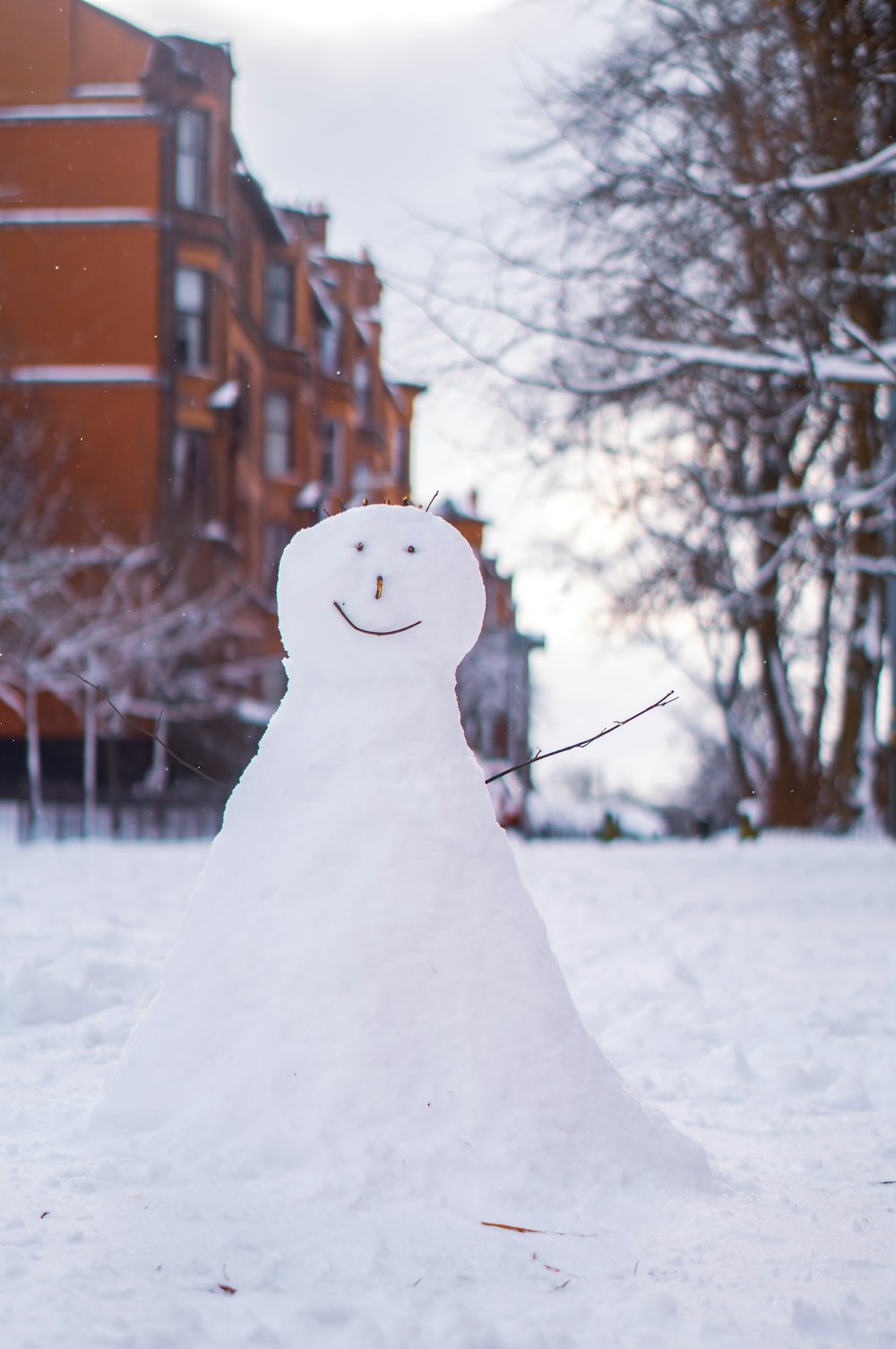 snowman near bare trees during daytime