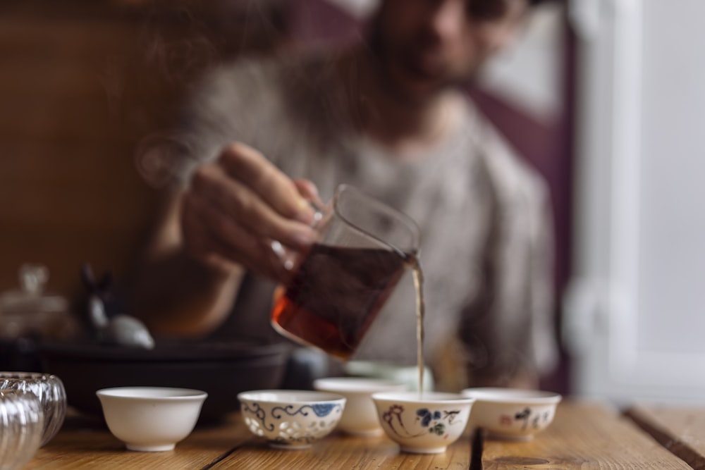 Femme en chemise blanche à manches longues tenant un verre à boire transparent