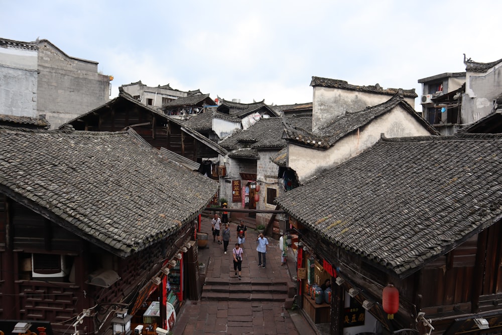 people walking on street between houses during daytime