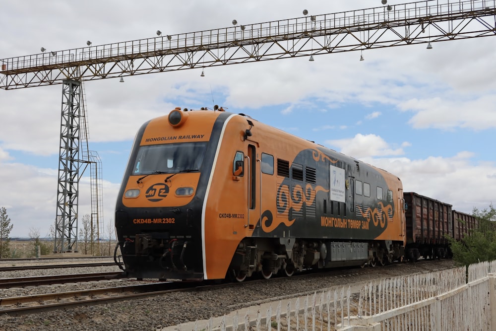 yellow and black train on rail tracks during daytime