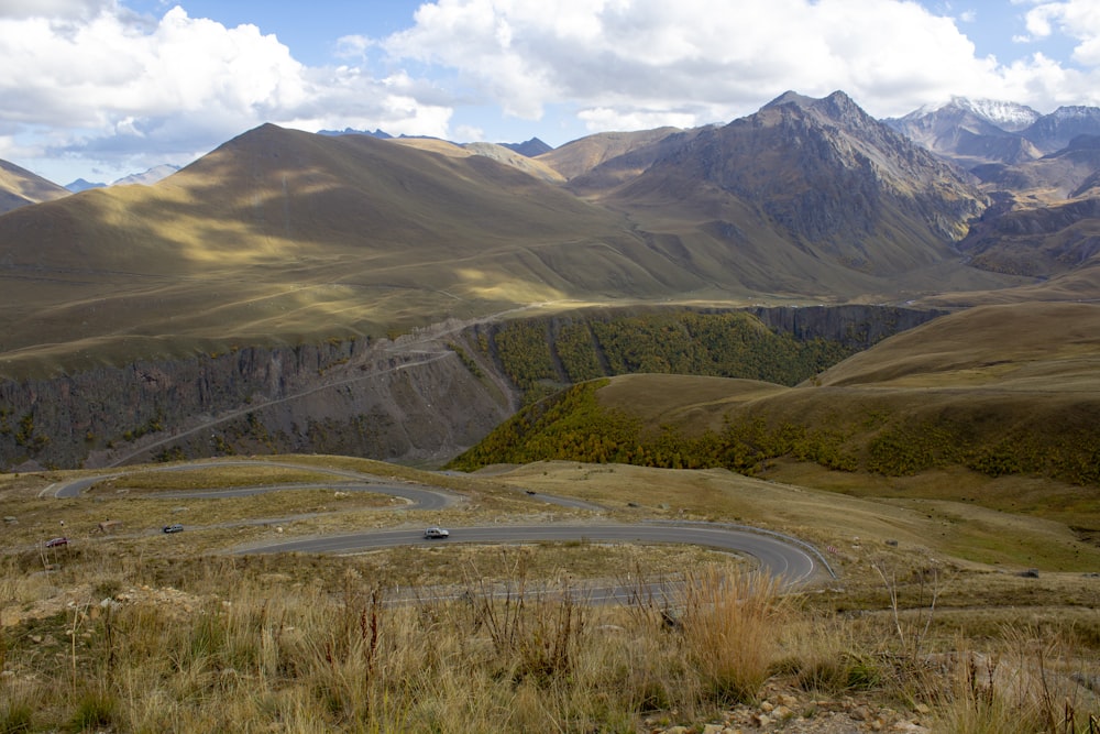 brown grass field near mountain during daytime