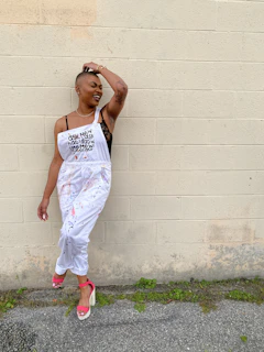 woman with cancer in white apron with block wall behind her