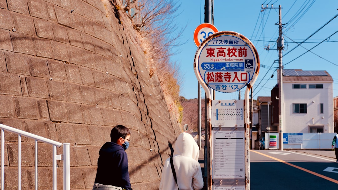 man in black jacket standing beside white horse during daytime