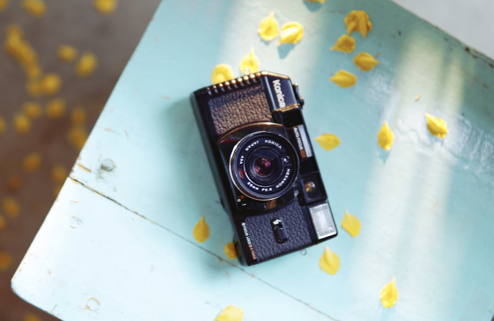 black and silver camera on blue table