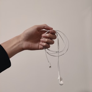 Stylish earphones tangled casually next to a smartphone.