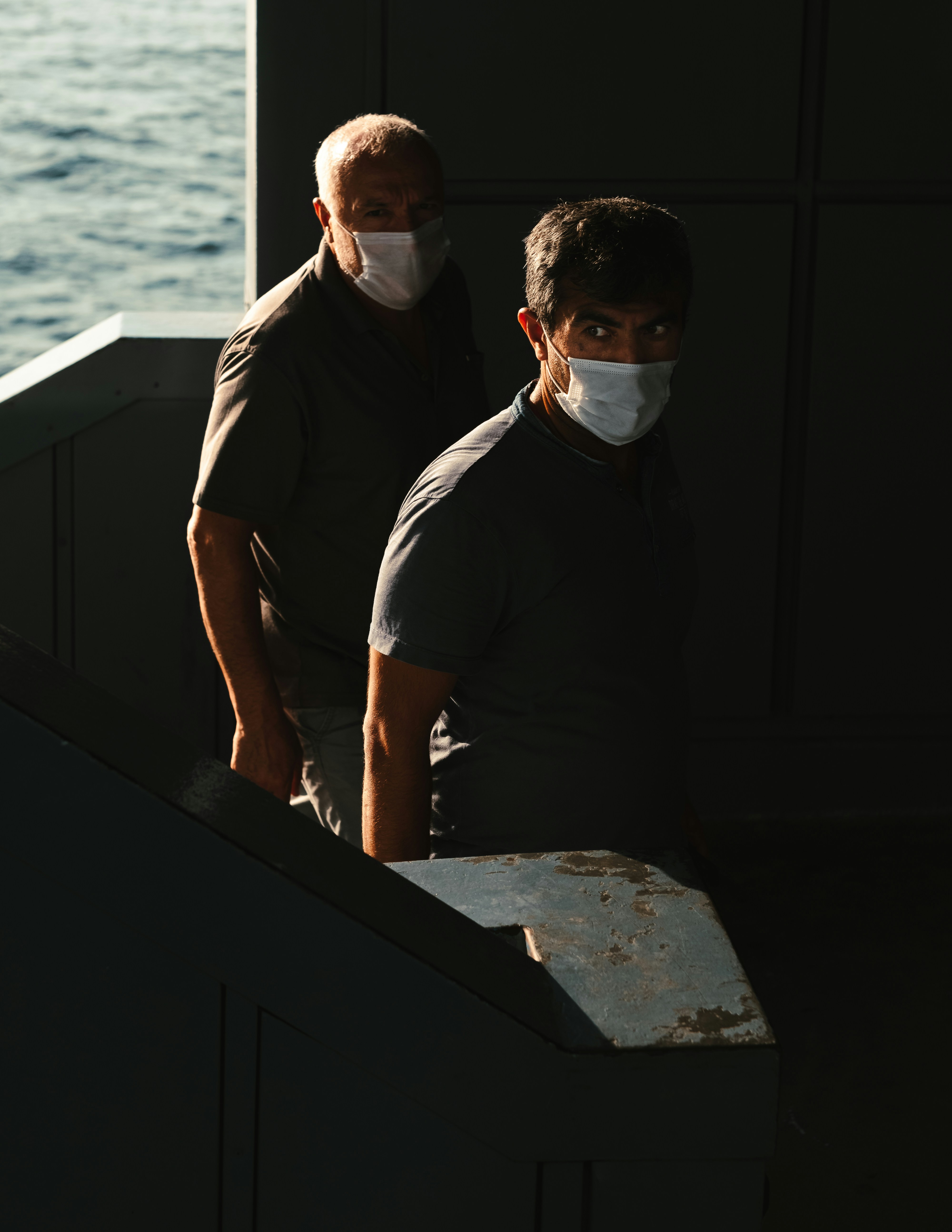 uomo in polo nera in piedi accanto all'uomo in t-shirt nera