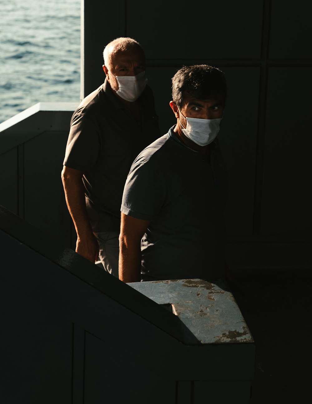 man in black polo shirt standing beside man in black t-shirt