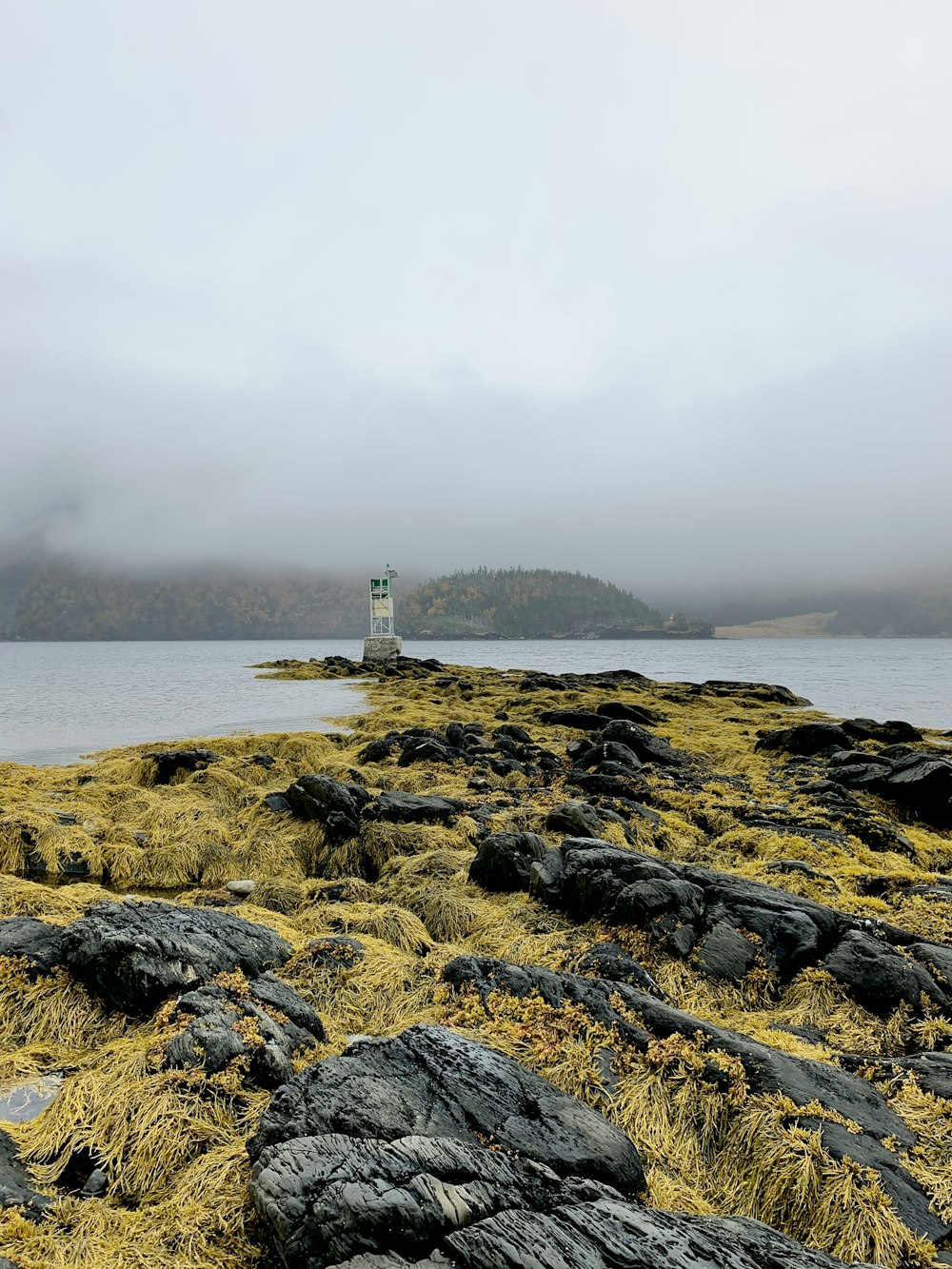 white lighthouse on rocky shore during daytime
