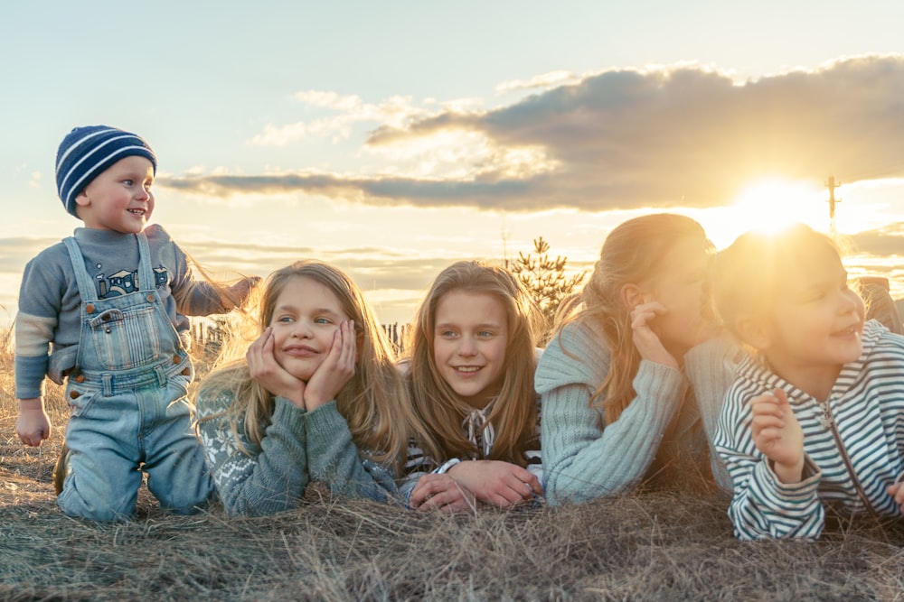 3 donne che si siedono sul campo d'erba durante il tramonto