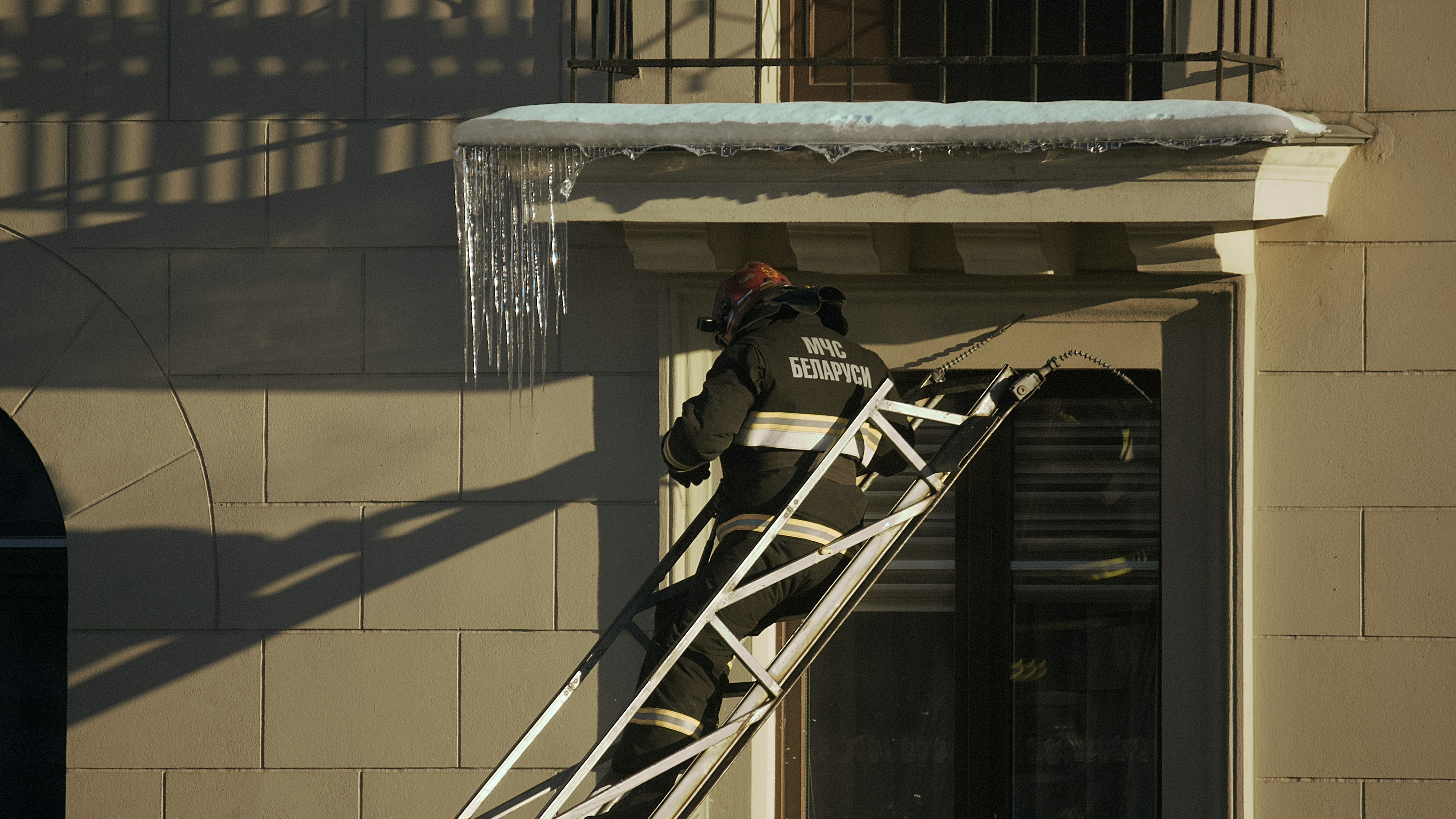 professional contractor inspecting gutters on a ladder - best gutter replacement company near me