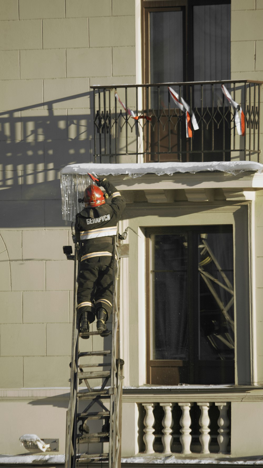 a man on a ladder painting a building