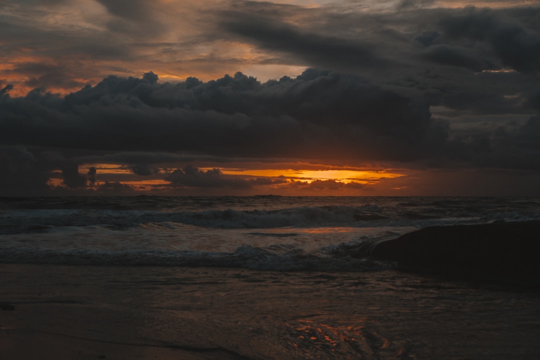 sea waves crashing on shore during sunset