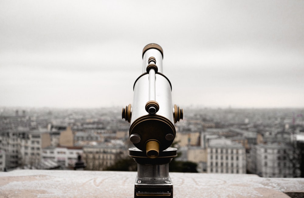 black and gold telescope on top of a building