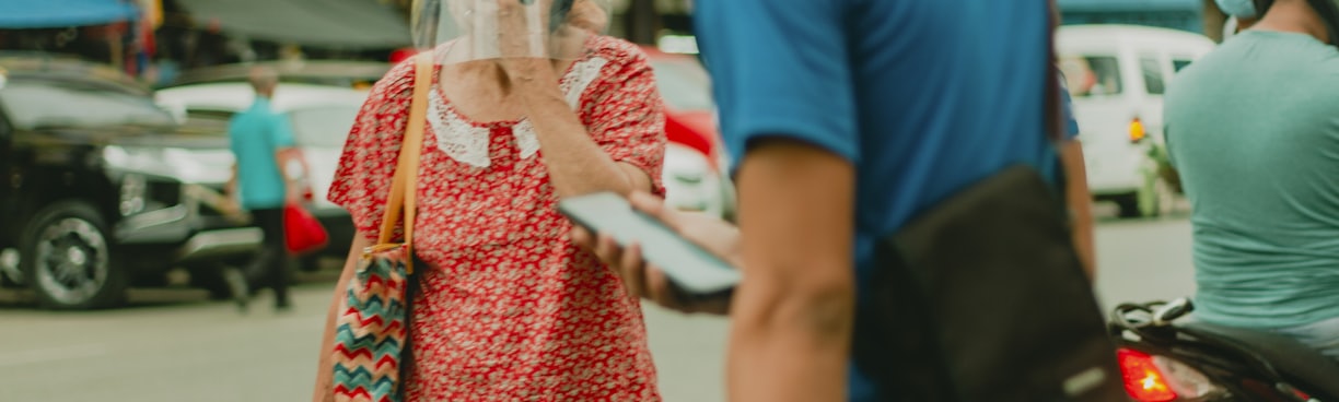 woman in red and white floral dress standing beside man in blue t-shirt